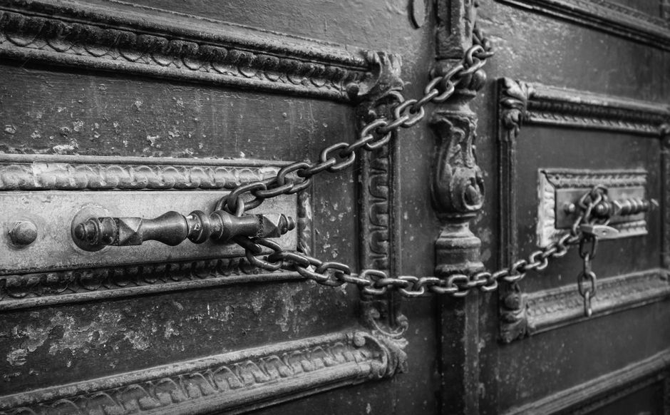 A dramatic black and white image of an antique chain-locked door in Istanbul, Türkiye.